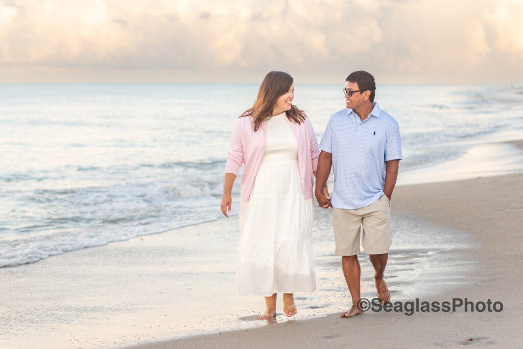 bi-racial couple holding hands walking on the beach at sunset at the Disney Vero Beach Resort