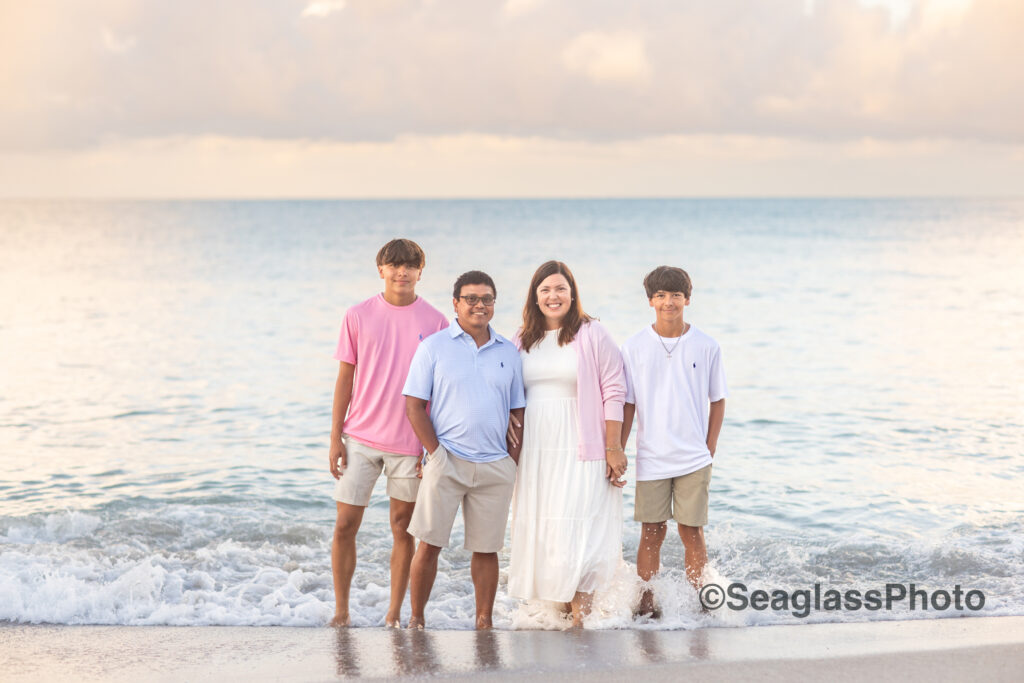 Sunset family portrait wearing pink, white and blue by the ocean at the Disney Vero Beach Florida 