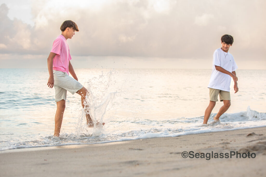 brothers at Disney Vero Beach Fl splashing in the ocean at sunset 