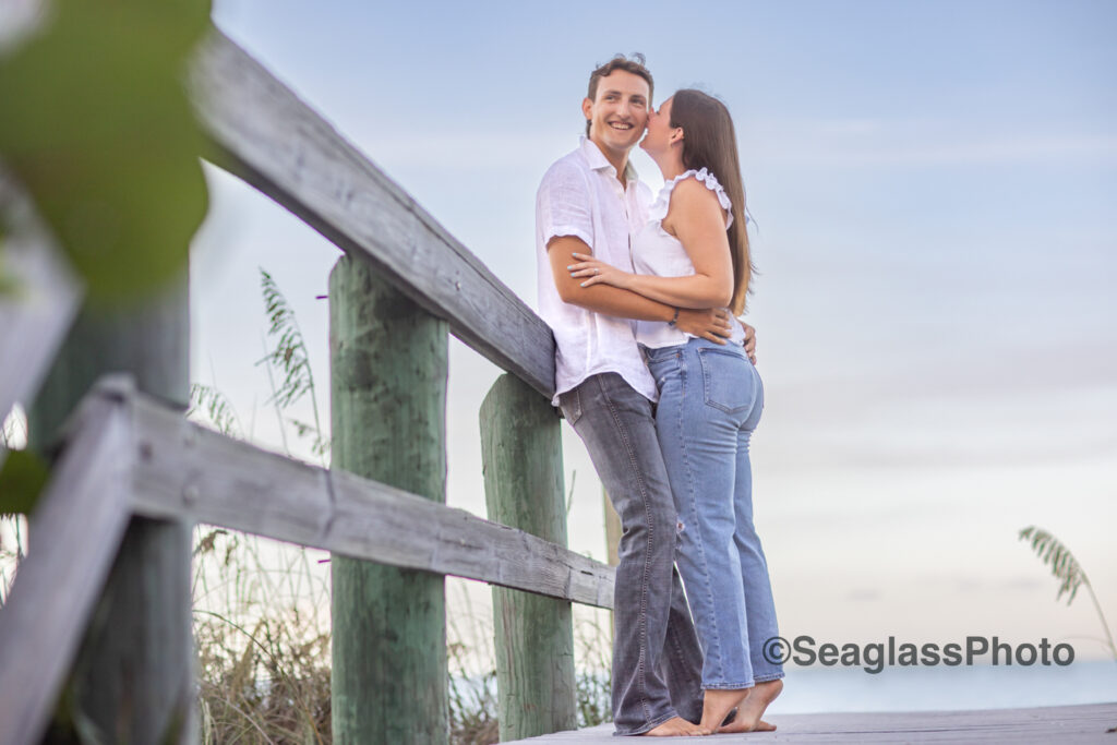 Couple wearing white shirt and jeans standing on a dock in Vero Beach for their engagement photoshoot