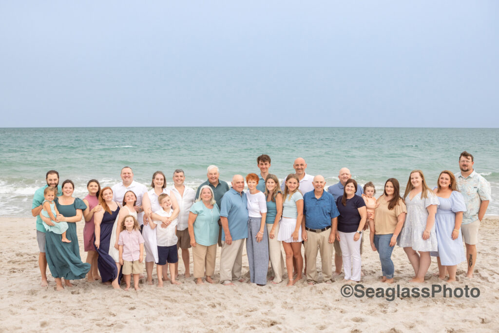 Family reunion photo with 30 people standing on the beach at the Vero Beach Disney resort