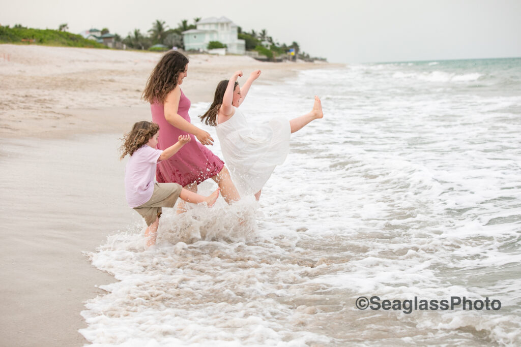 siblings kicking in the waves at the Vero Beach Disney Resort 