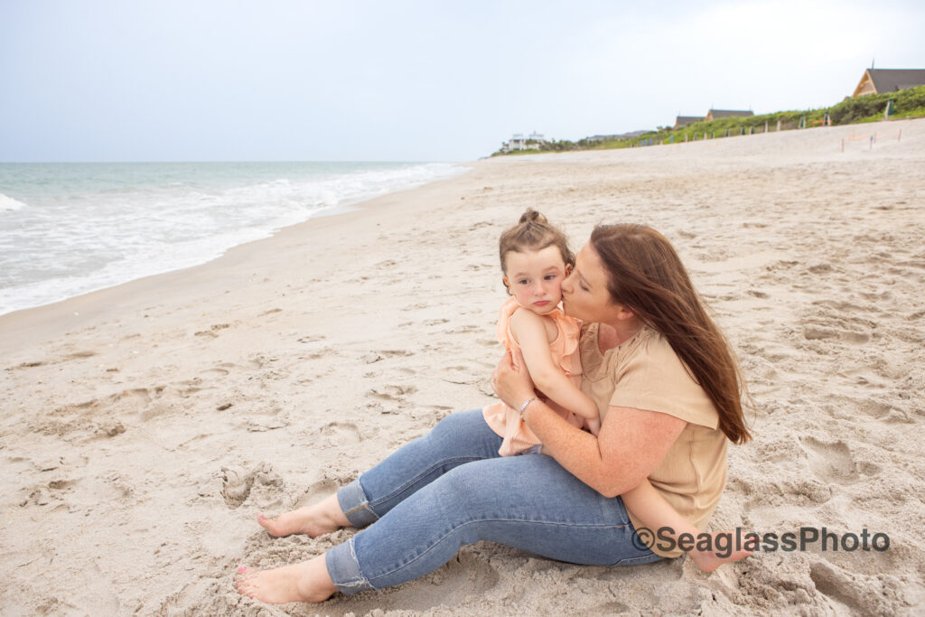 mom sitting on the beach with ehr daughter at the Disney Vero Beach Resort