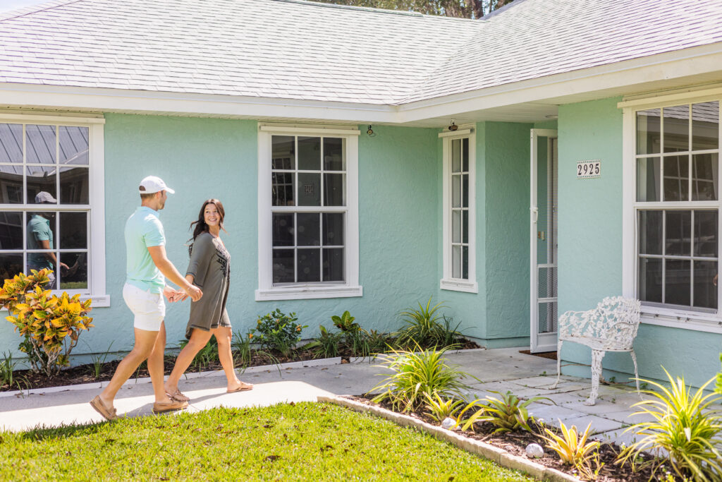 husband and wife walking into their first home as a couple in Vero Beach Florida with Compass Reality 