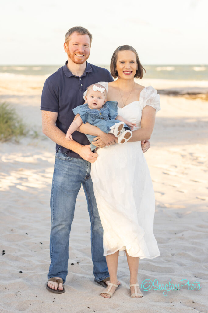 A man and woman holding a baby on a beach. Vero Beach Photoshoot